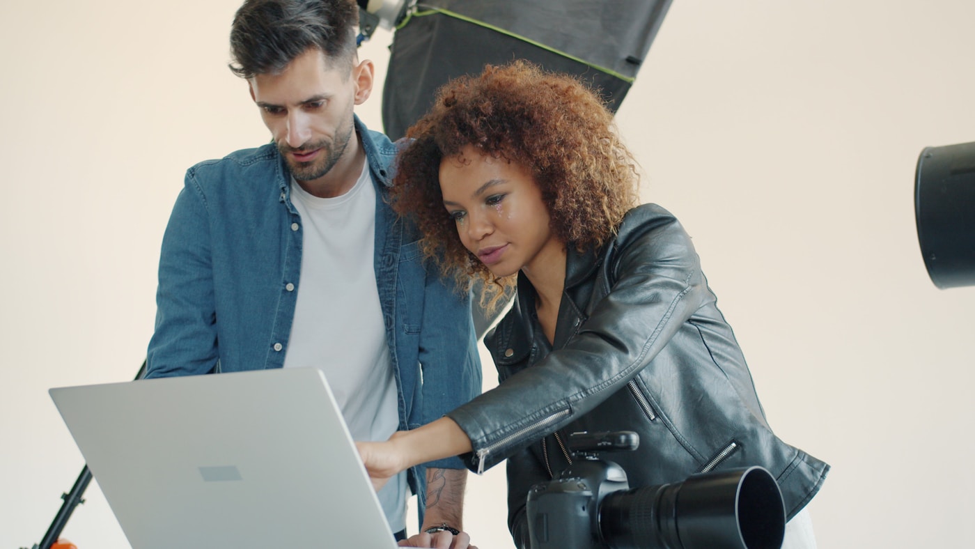Marketing team reviewing ad footage on a laptop
